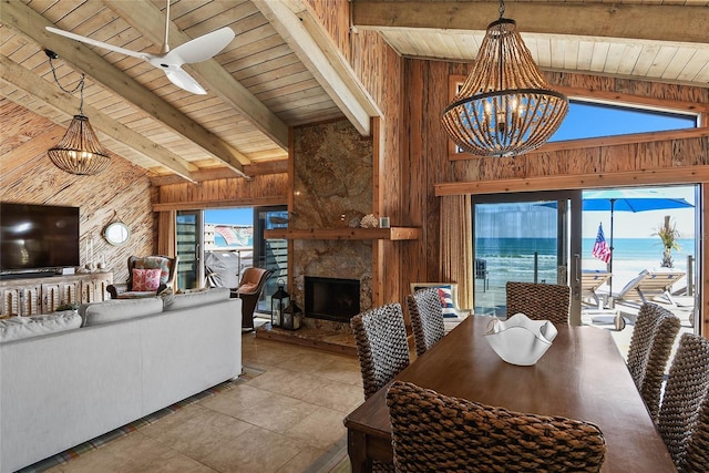 dining area featuring a wealth of natural light, beam ceiling, wooden walls, and wood ceiling