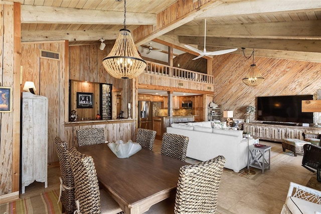 dining room featuring visible vents, wood walls, wood ceiling, and beamed ceiling