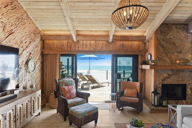 living room with wooden ceiling, beamed ceiling, a water view, and wood walls