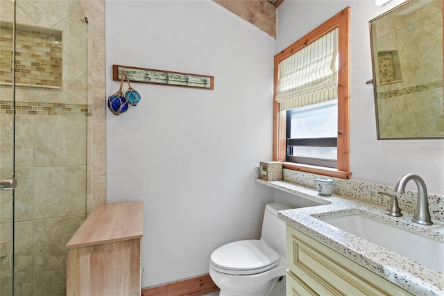 bathroom featuring vanity, toilet, and tiled shower