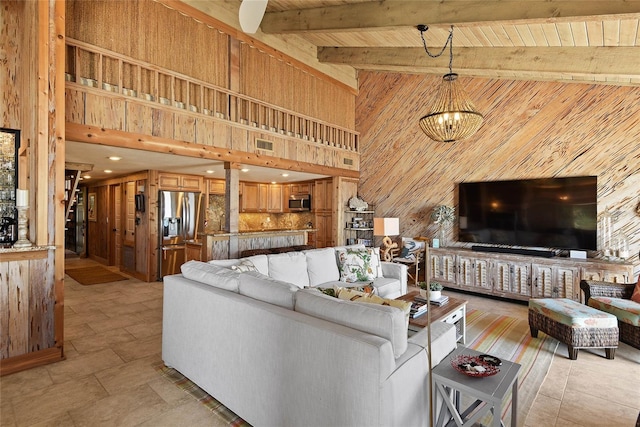 living room featuring beamed ceiling, visible vents, high vaulted ceiling, wood walls, and wood ceiling