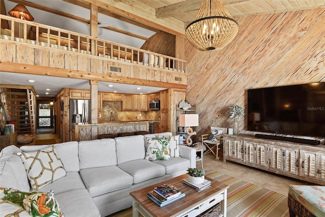 living room featuring beamed ceiling, visible vents, wood walls, and a chandelier