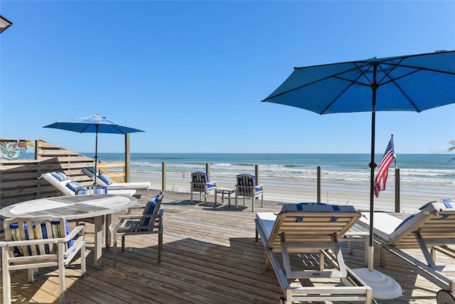 view of dock featuring a beach view and a water view