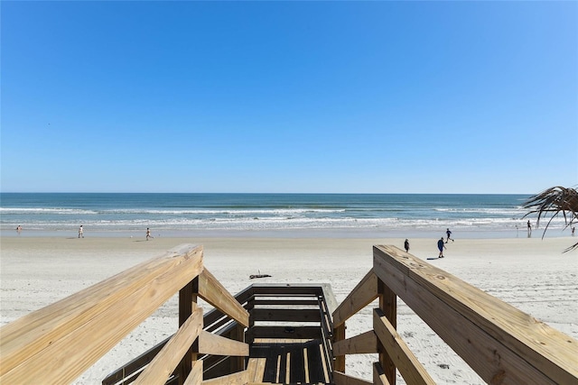 surrounding community with a water view and a view of the beach