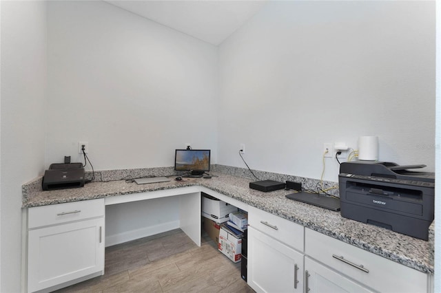 home office featuring light wood-style flooring and built in study area