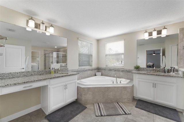 full bath featuring visible vents, two vanities, a stall shower, a sink, and a bath