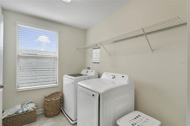 laundry area with light tile patterned floors, laundry area, and washing machine and clothes dryer