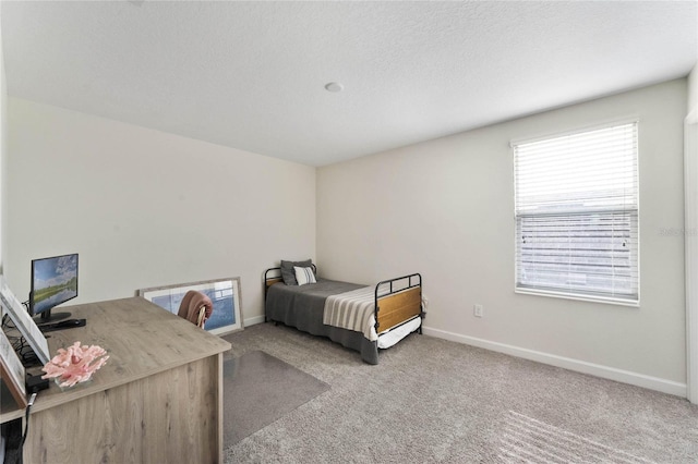 bedroom featuring baseboards, carpet floors, and a textured ceiling