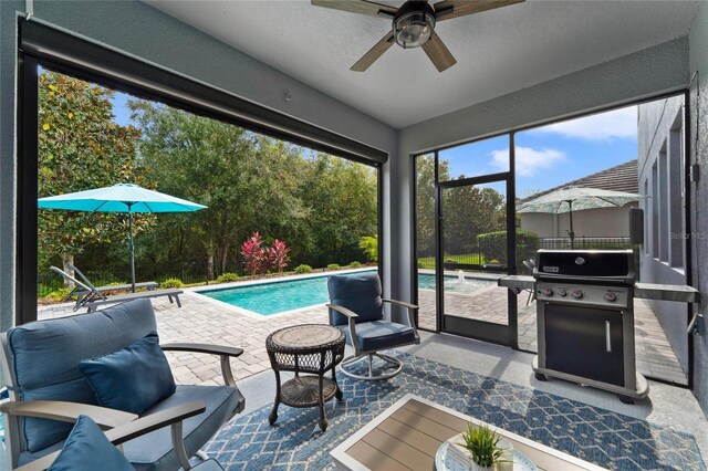 outdoor pool featuring area for grilling, ceiling fan, and a patio area