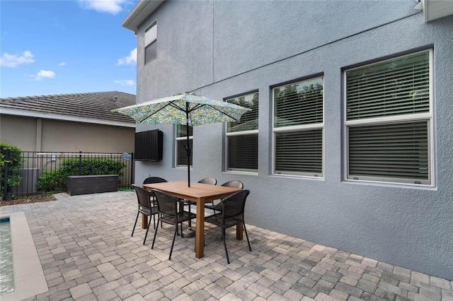 view of patio featuring outdoor dining area and fence