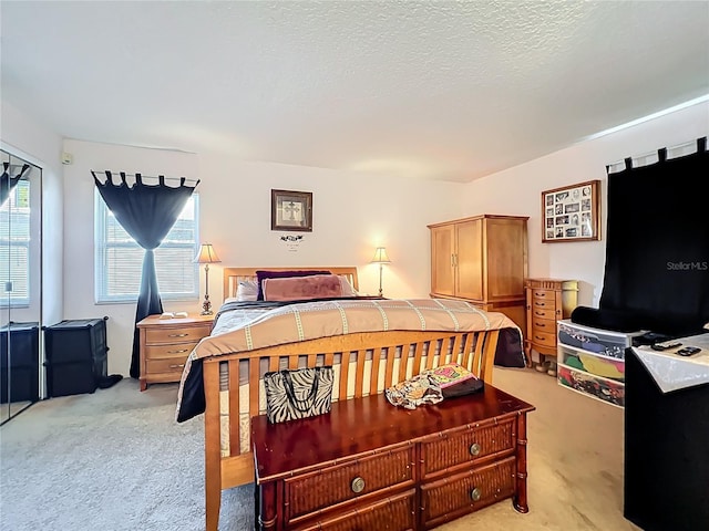 bedroom with light carpet and a textured ceiling