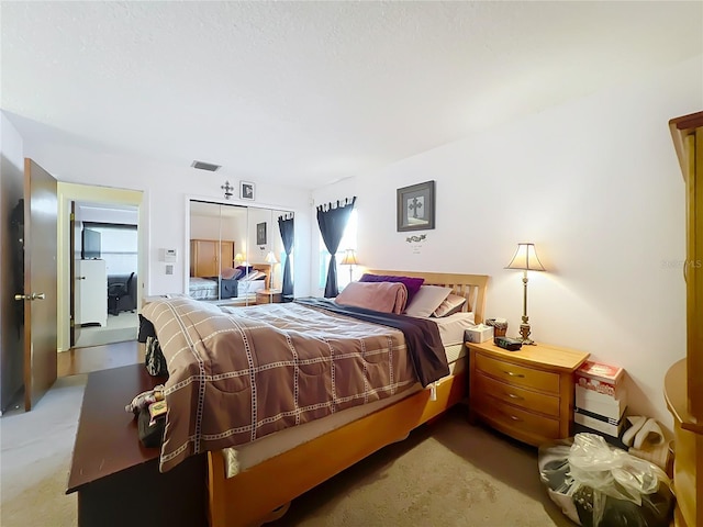 carpeted bedroom featuring a closet and visible vents