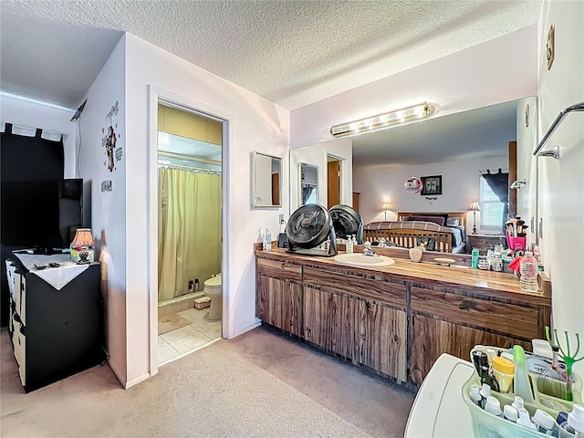 full bathroom featuring vanity, toilet, a stall shower, and a textured ceiling