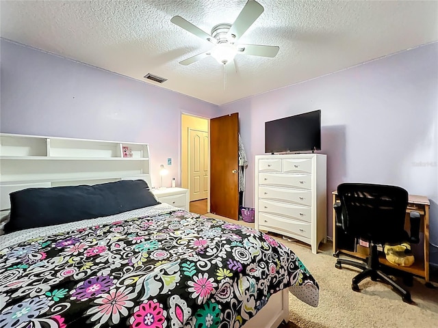 bedroom with visible vents, carpet, a ceiling fan, and a textured ceiling