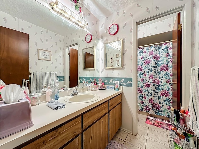 bathroom with tile patterned flooring, curtained shower, wallpapered walls, vanity, and a textured ceiling