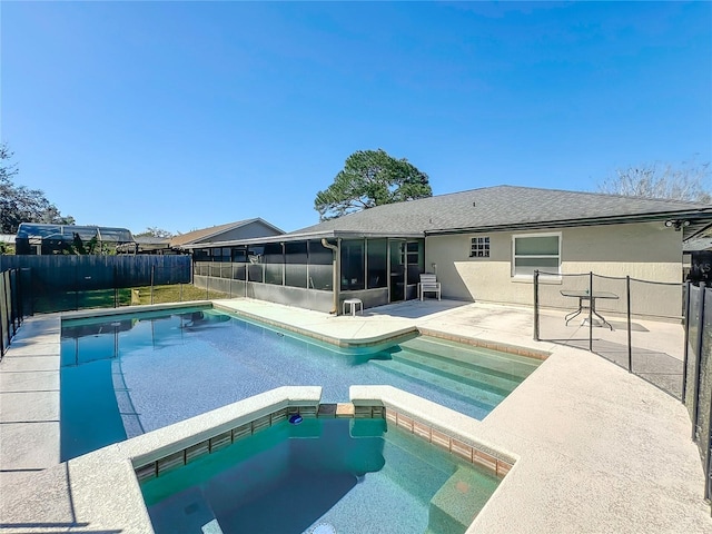 view of swimming pool featuring a patio area, a pool with connected hot tub, fence, and a sunroom