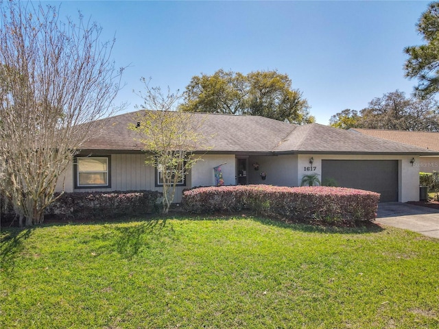 ranch-style home featuring roof with shingles, driveway, an attached garage, stucco siding, and a front lawn