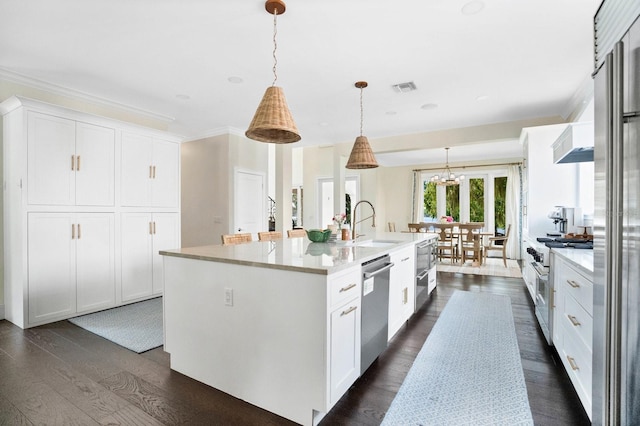 kitchen featuring high quality appliances, an island with sink, white cabinets, dark wood-style flooring, and hanging light fixtures