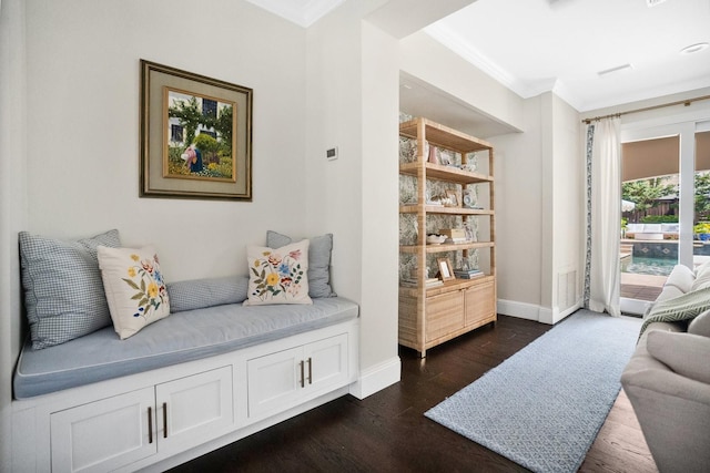 living area with baseboards, dark wood-type flooring, and ornamental molding