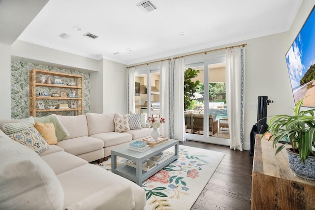 living room with dark wood finished floors, visible vents, and crown molding