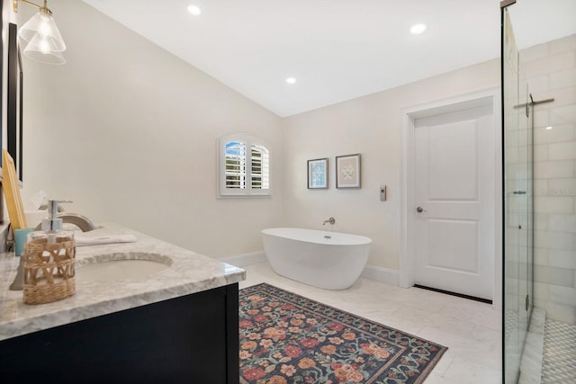 bathroom with baseboards, a freestanding bath, double vanity, vaulted ceiling, and a stall shower