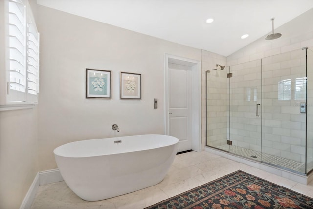 bathroom with baseboards, a soaking tub, lofted ceiling, a shower stall, and marble finish floor