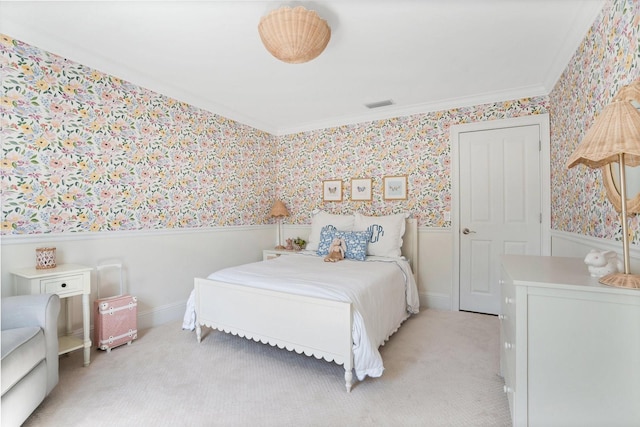 bedroom with visible vents, a wainscoted wall, wallpapered walls, light carpet, and crown molding