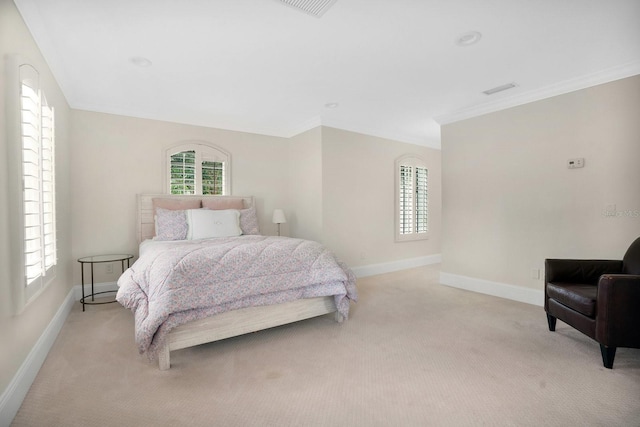 bedroom with ornamental molding, multiple windows, baseboards, and light carpet