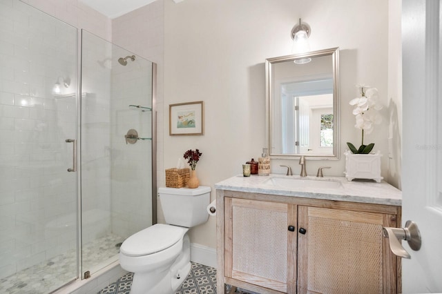 bathroom featuring baseboards, toilet, a stall shower, and vanity