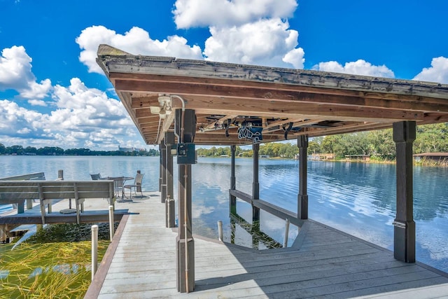 dock area with boat lift and a water view