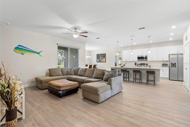 living area with a ceiling fan, visible vents, baseboards, recessed lighting, and light wood-style floors