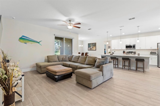 living area with a ceiling fan, baseboards, visible vents, light wood-style flooring, and recessed lighting