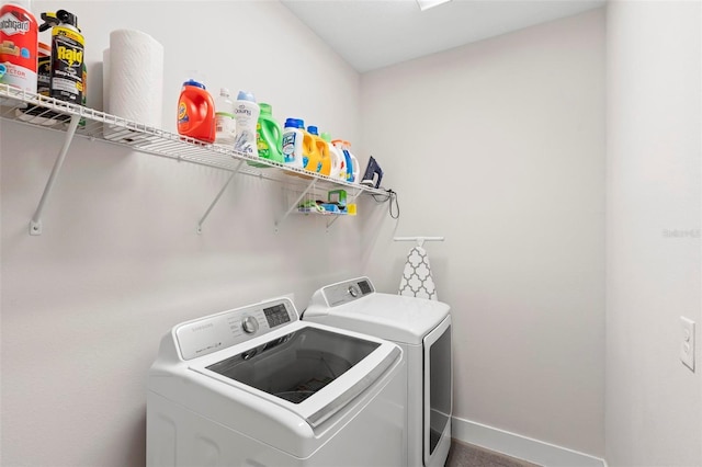 laundry room with laundry area, washing machine and dryer, and baseboards