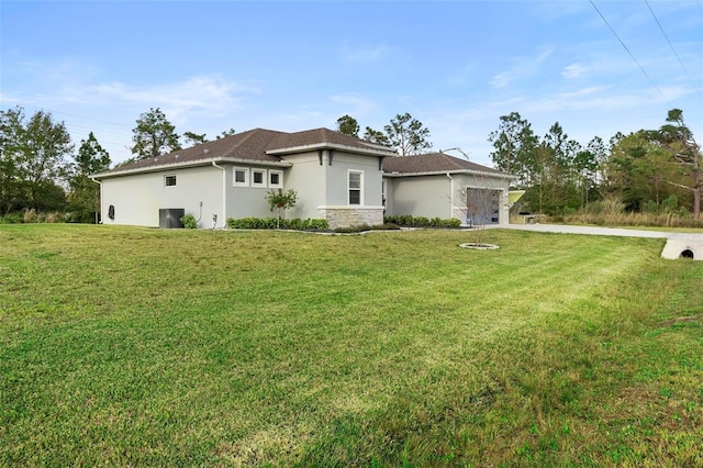 view of front facade with stucco siding, stone siding, concrete driveway, a front yard, and a garage