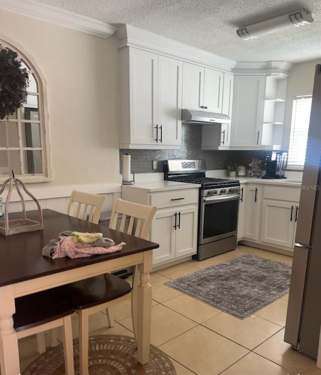 kitchen featuring under cabinet range hood, open shelves, tasteful backsplash, stainless steel appliances, and light tile patterned floors