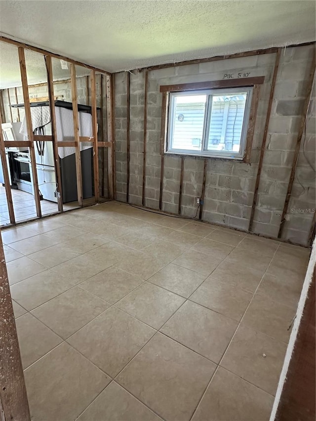 empty room featuring a textured ceiling and concrete block wall