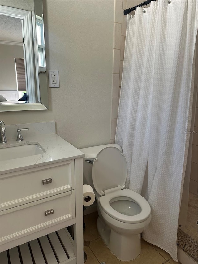 bathroom with tile patterned flooring, toilet, vanity, and a stall shower