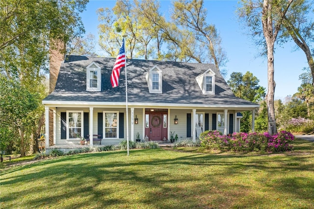 view of front facade with a chimney, covered porch, and a front lawn