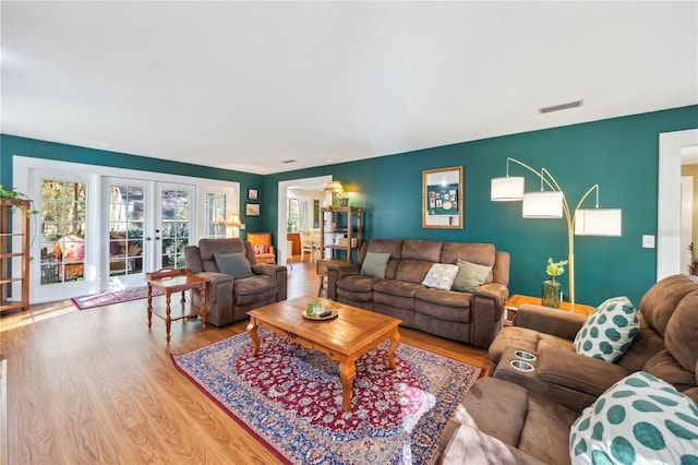 living room featuring wood finished floors, french doors, and visible vents