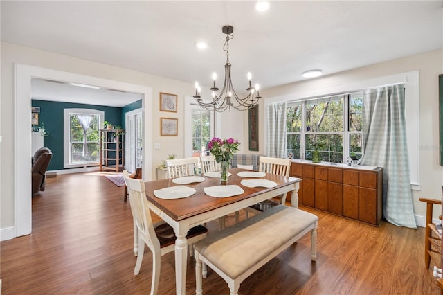 dining room featuring an inviting chandelier, light wood-style flooring, and baseboards