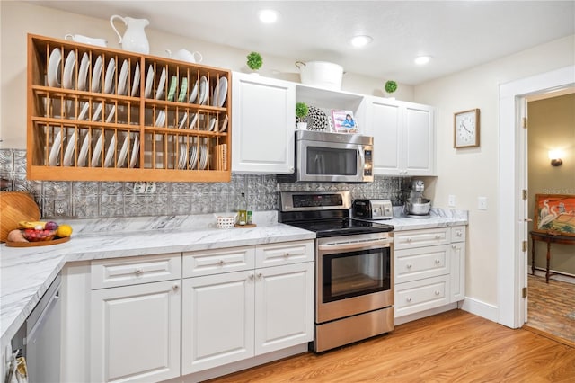 kitchen with decorative backsplash, light wood-style flooring, appliances with stainless steel finishes, white cabinets, and open shelves