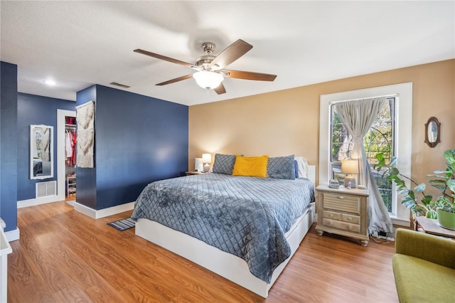 bedroom featuring visible vents, baseboards, a closet, and wood finished floors