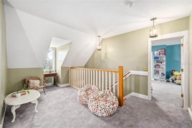 living area featuring carpet, vaulted ceiling, an upstairs landing, and baseboards