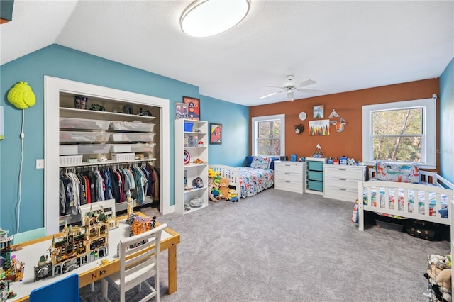 bedroom featuring a closet, ceiling fan, carpet, and vaulted ceiling