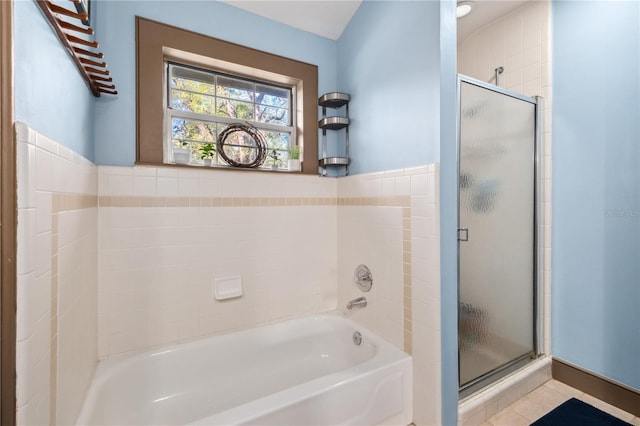 full bathroom featuring tile patterned flooring, a shower stall, and a garden tub