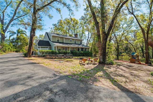 view of front of home featuring a playground and a chimney