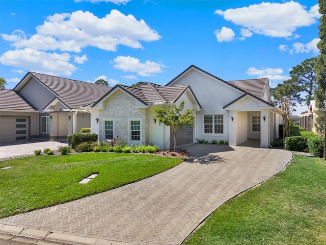 view of front of home with decorative driveway, an attached garage, and stucco siding