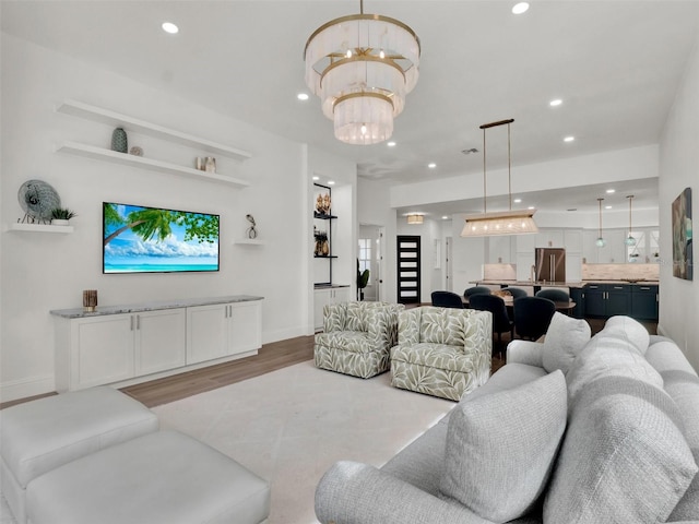 living area featuring a notable chandelier, recessed lighting, baseboards, and wood finished floors