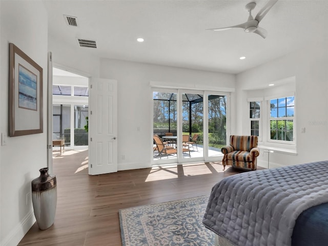 bedroom with access to outside, multiple windows, wood finished floors, and visible vents