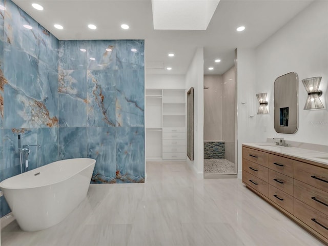 full bathroom with vanity, tiled shower, a soaking tub, recessed lighting, and tile walls